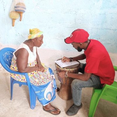 Daniel assists a widow in Johnsonville to fill out a registration form